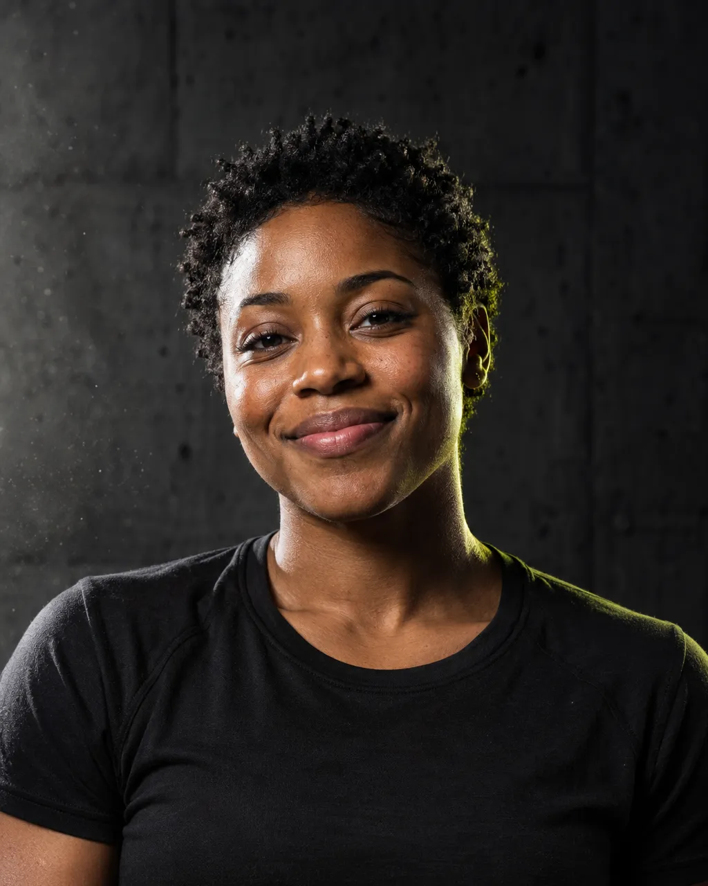 A Black woman mobility coach in her late twenties with short natural hair, black t-shirt