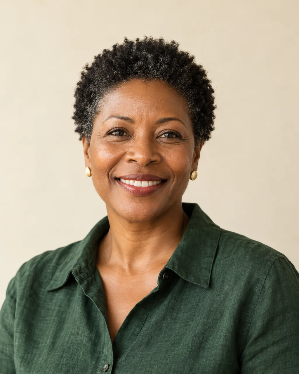 Studio-style team portrait of a confident Black woman in her late forties, executive director, short natural hair,…